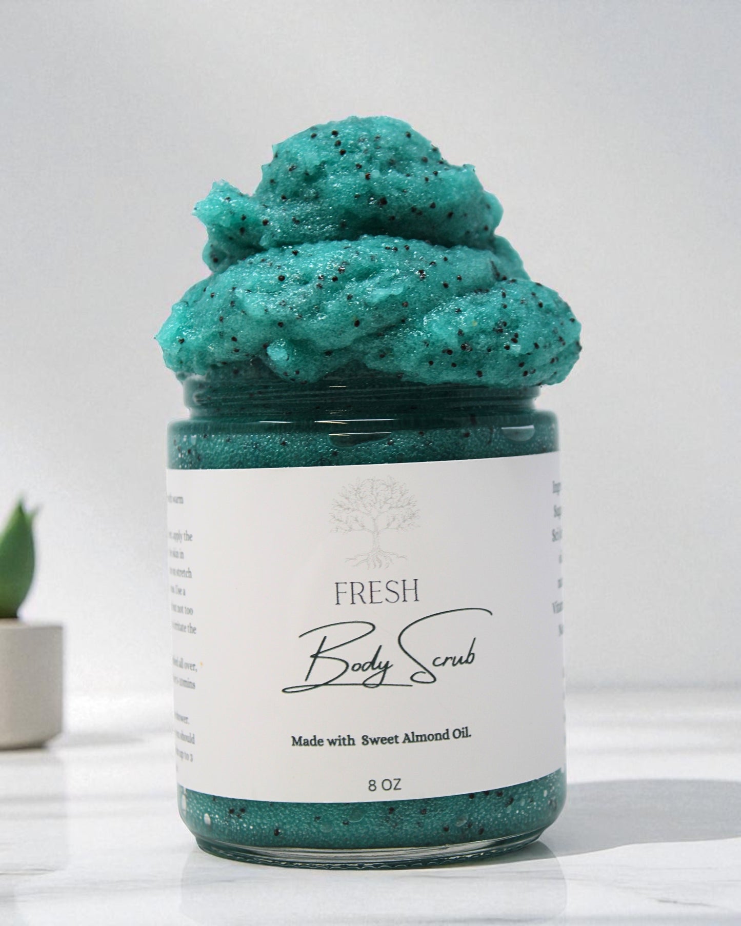 Jar of green body scrub with a white label on a light background