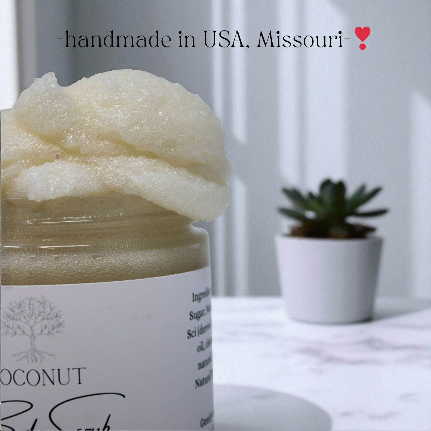 Jar of coconut body scrub with a plant in the background, labeled 'handmade in USA, Missouri'.