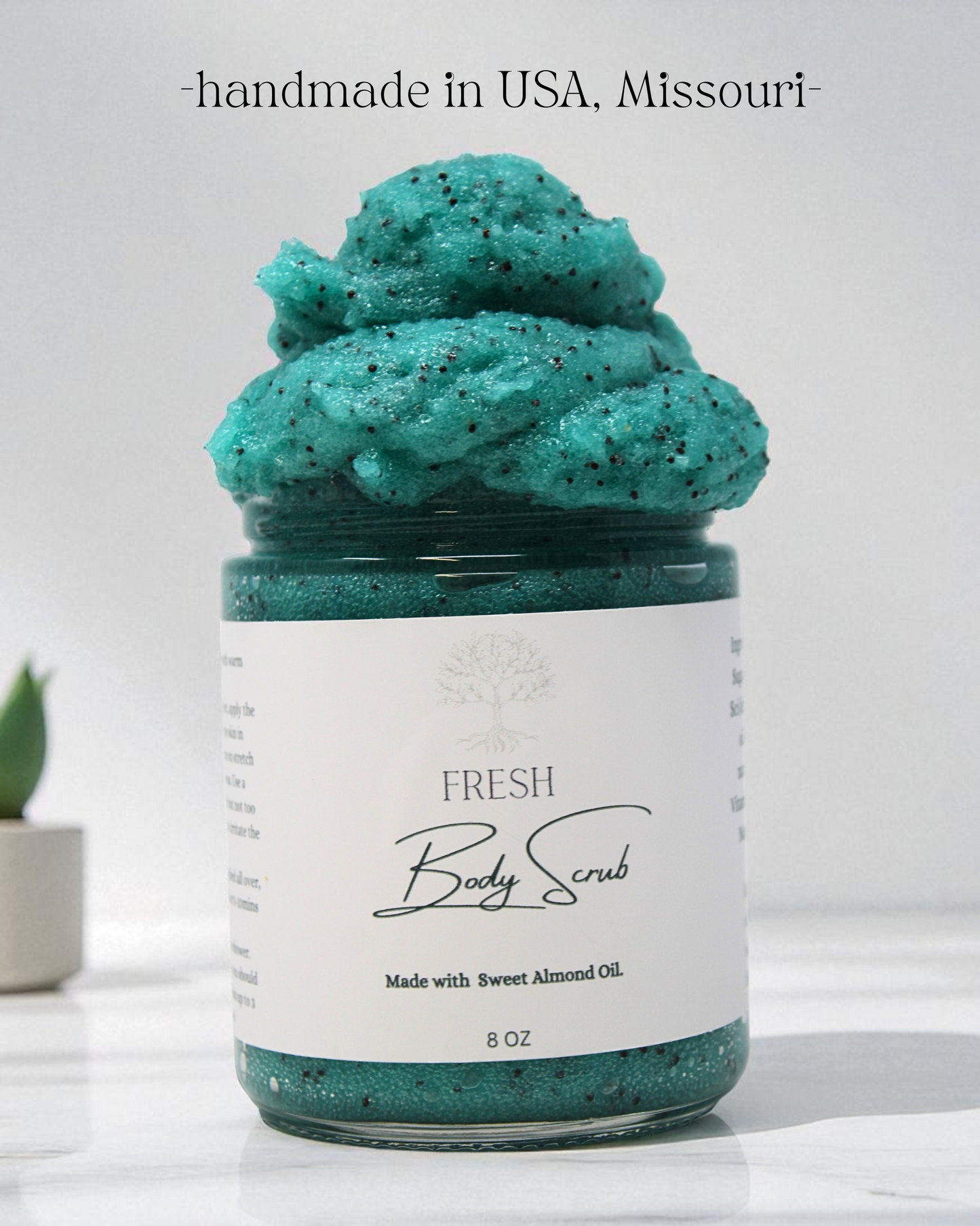 Jar of green body scrub with a white label on a light background