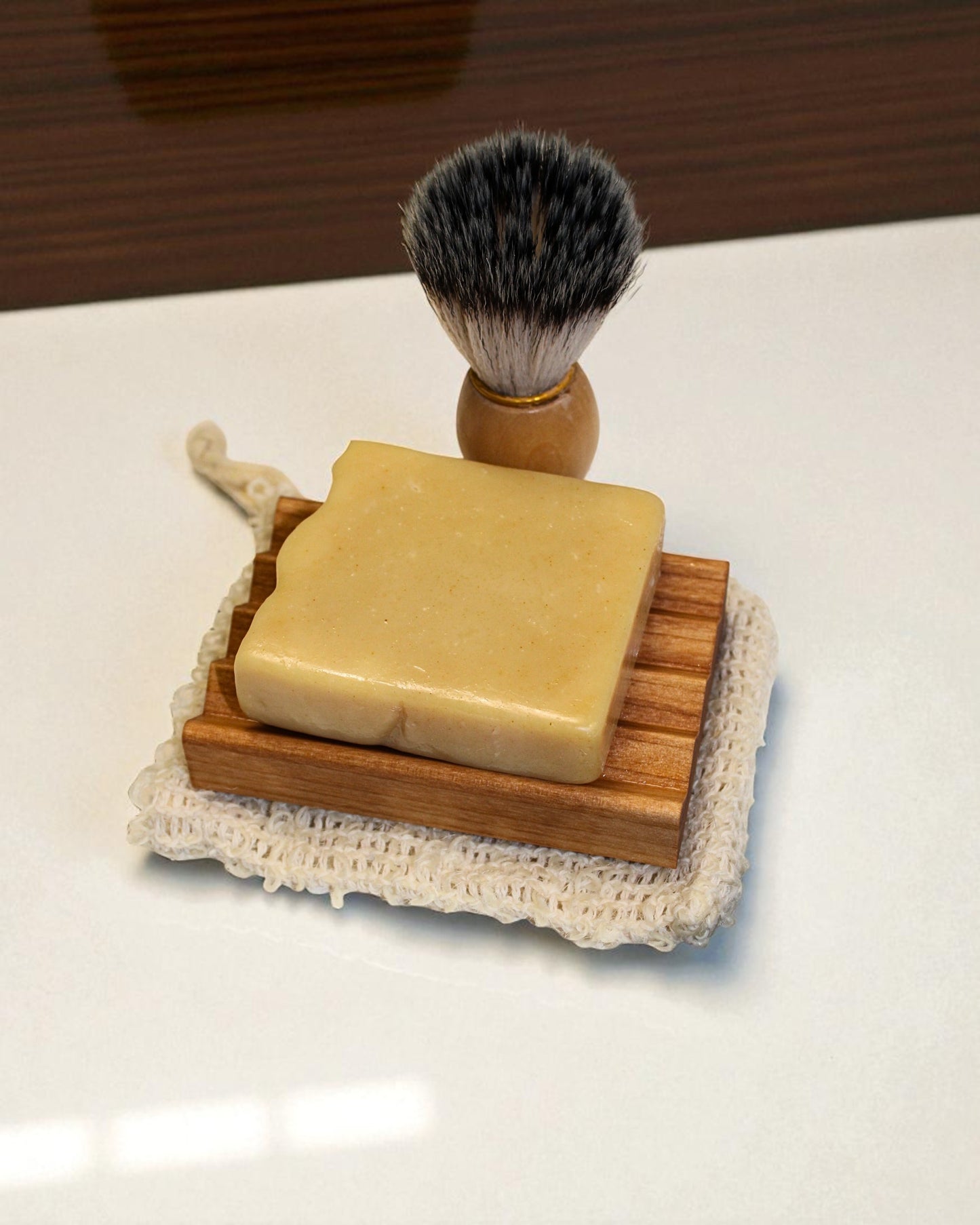 Shaving brush and soap on a wooden stand with a white background